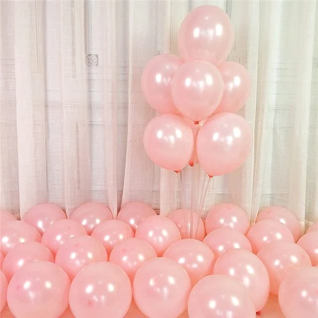 Pink balloons decorating a festive area with a cluster of balloons above and scattered ones below.