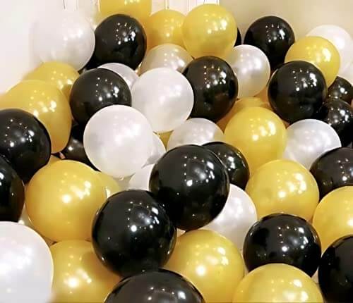 Colorful assortment of black, white, and gold balloons for party decoration, perfect for celebrations and events.