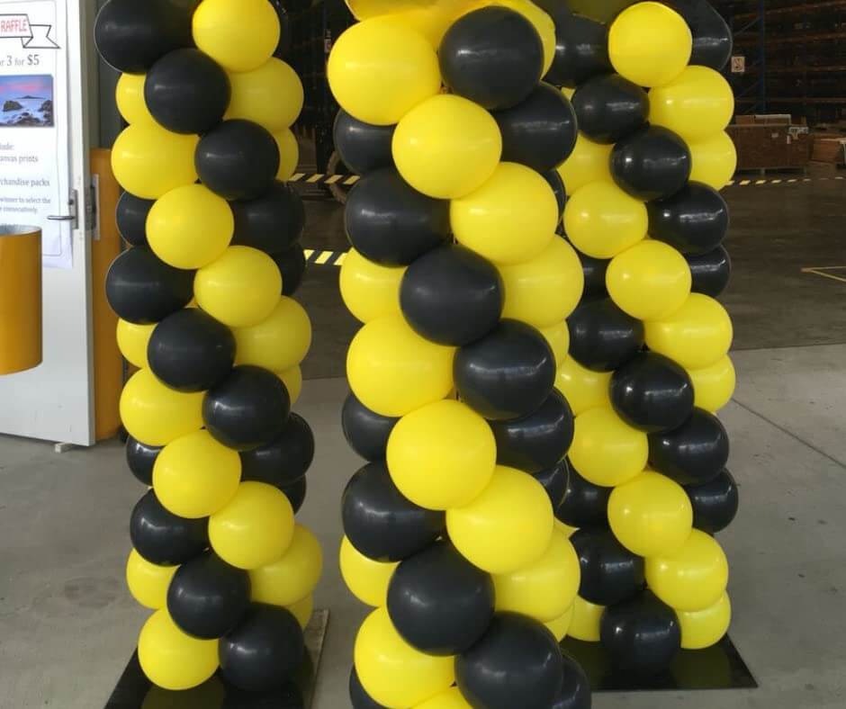 Yellow and black balloon columns for party decoration, perfect for events such as birthdays, weddings, and celebrations.
